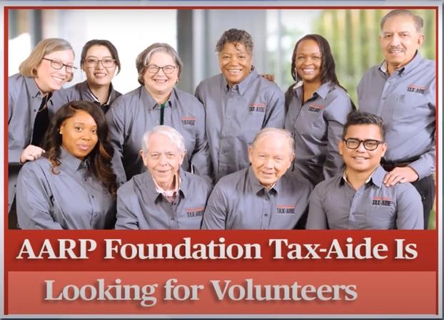 A group of smiling people wearing grey Tax-Aide volunteer shirts